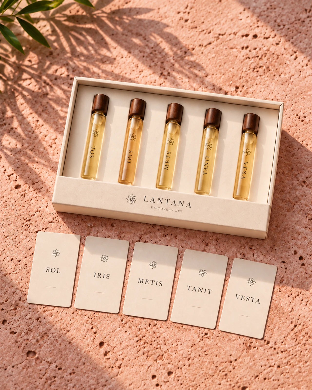 Five slender Lantana fragrance samples in an ivory tray, accompanied by five mini ritual cards on warm limestone.