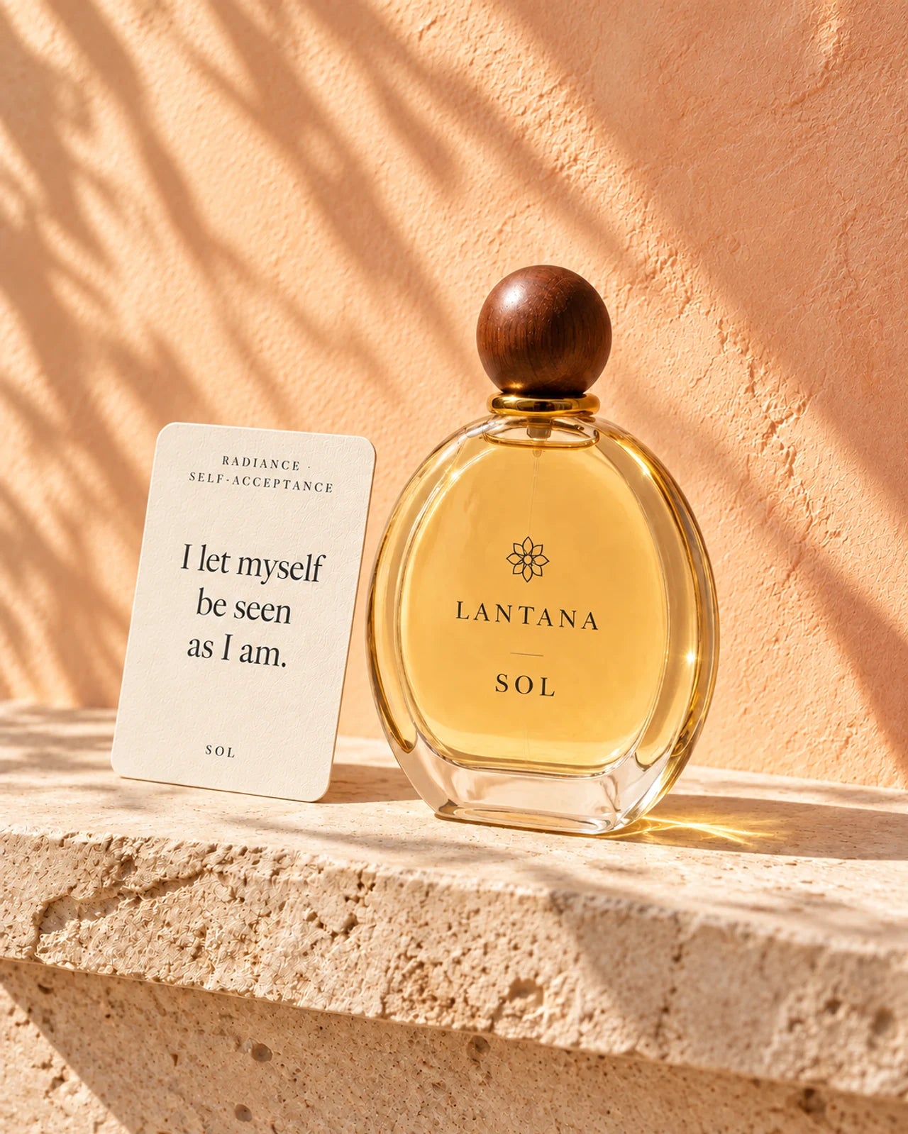 One oval SOL perfume bottle with a spherical wooden cap and its ivory Radiance and Self-Acceptance ritual card on sunlit limestone.